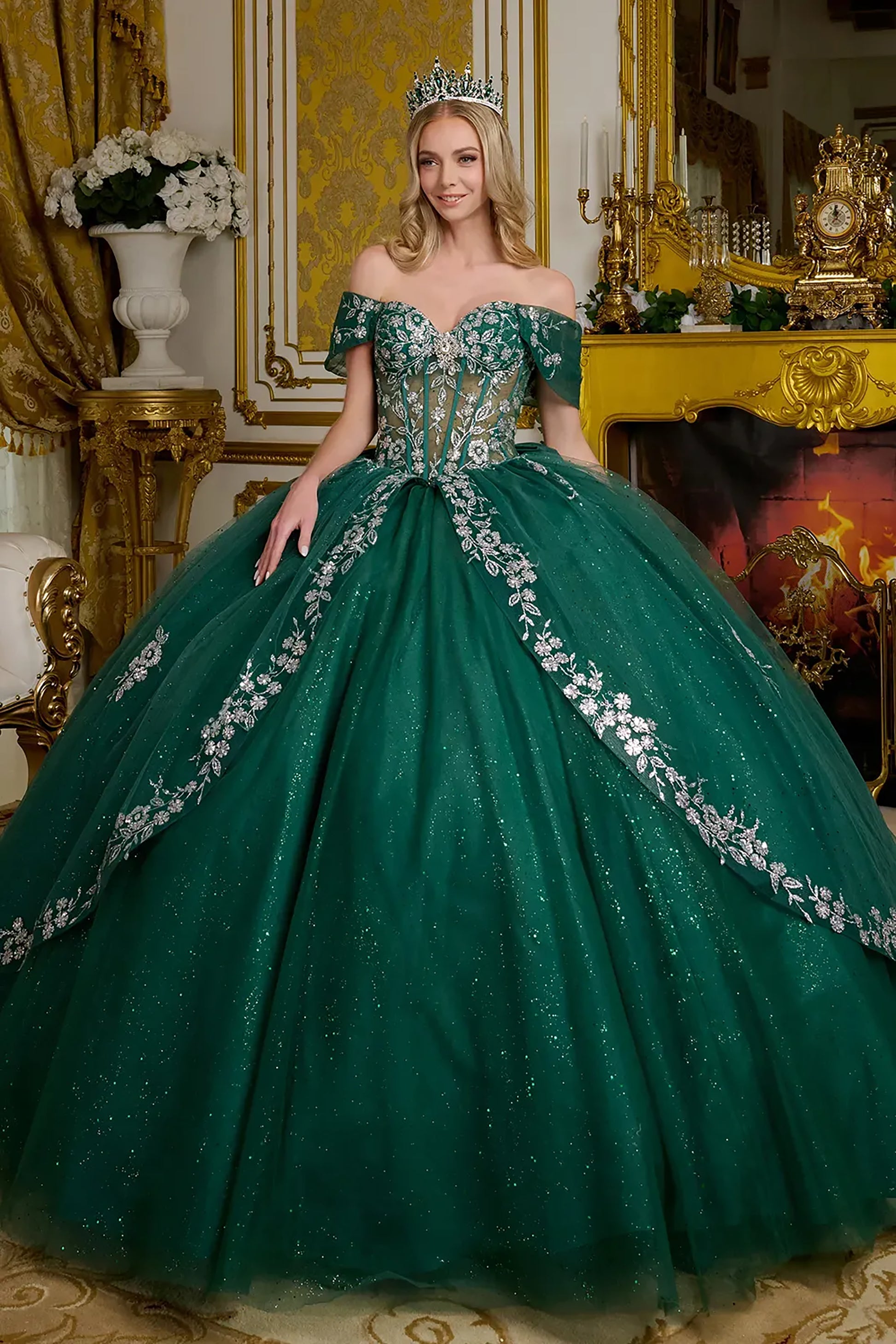 Woman in a green gown with floral details in an ornate room.
