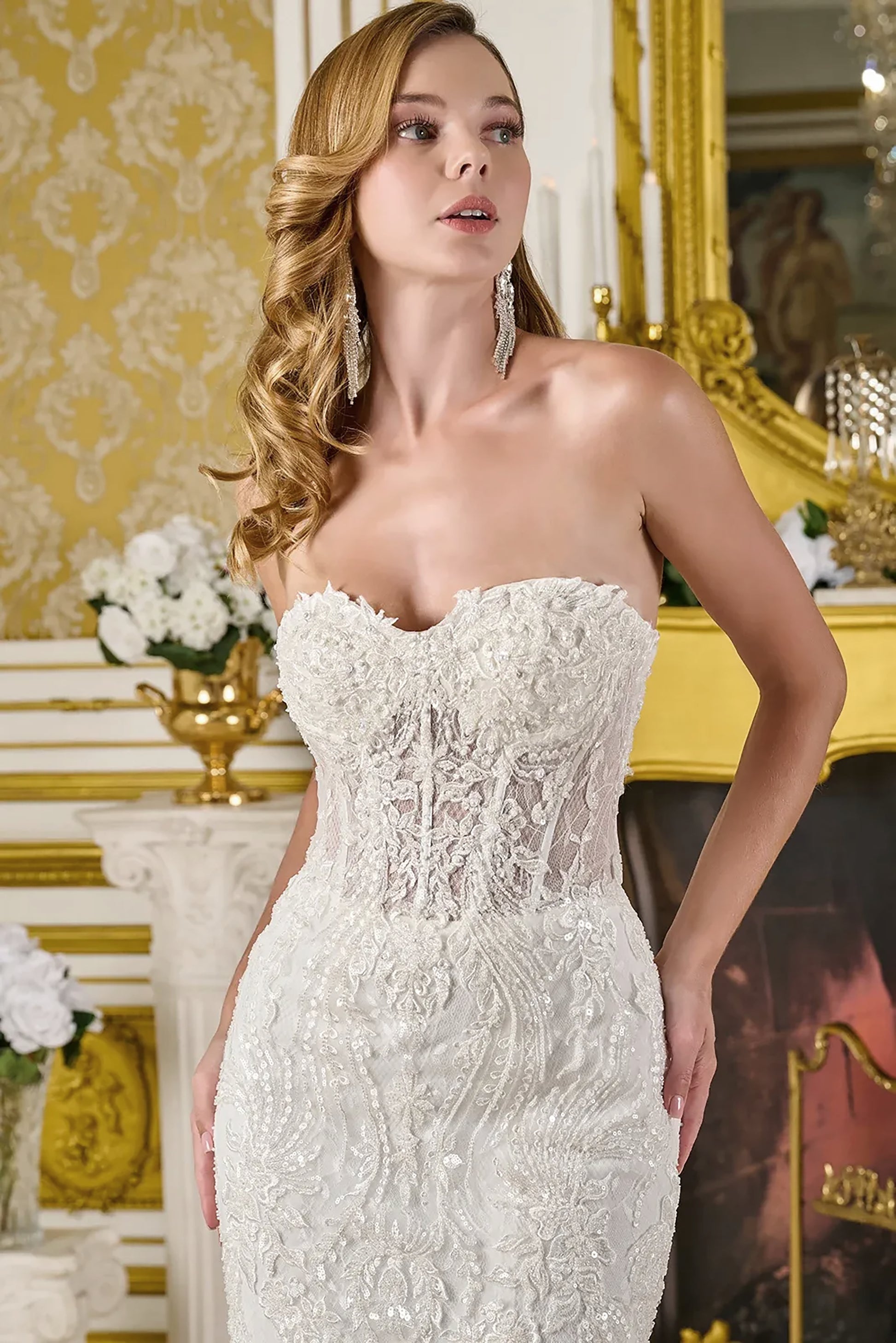 Woman wearing a white lace wedding dress in an elegant interior setting.
