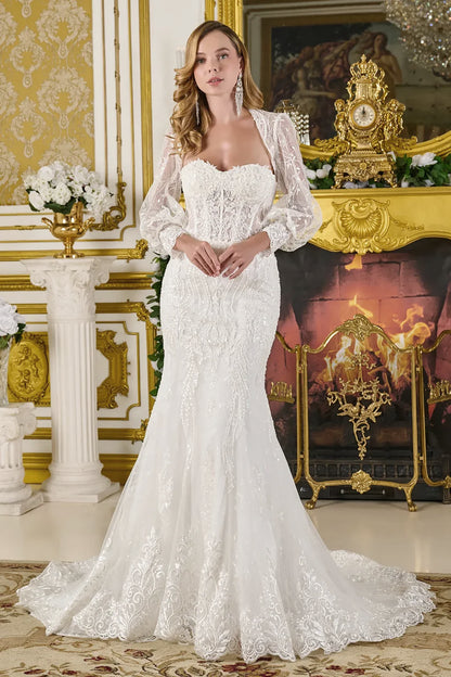 Woman in a white lace wedding dress standing in an ornate room with gold accents.