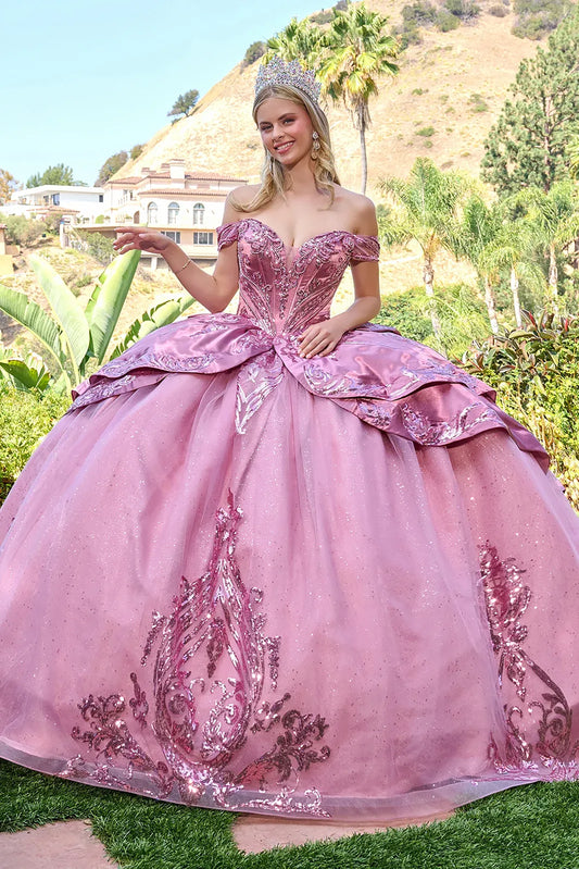 Woman in a dusty rose quinceañera dress with a tiara outdoors.