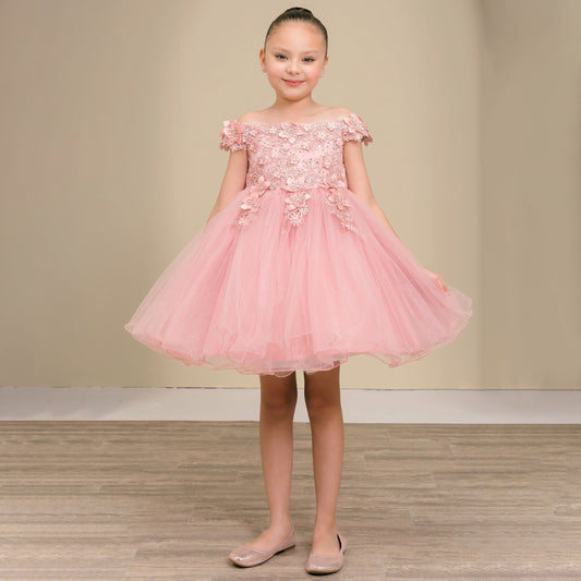 Young girl wearing a pink dress with floral details on a plain background