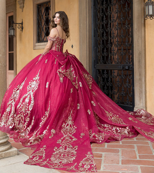 Woman in a pink and gold embroidered gown standing in front of a building entrance.