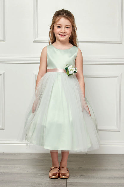 Young girl in a light green dress with a white wall background