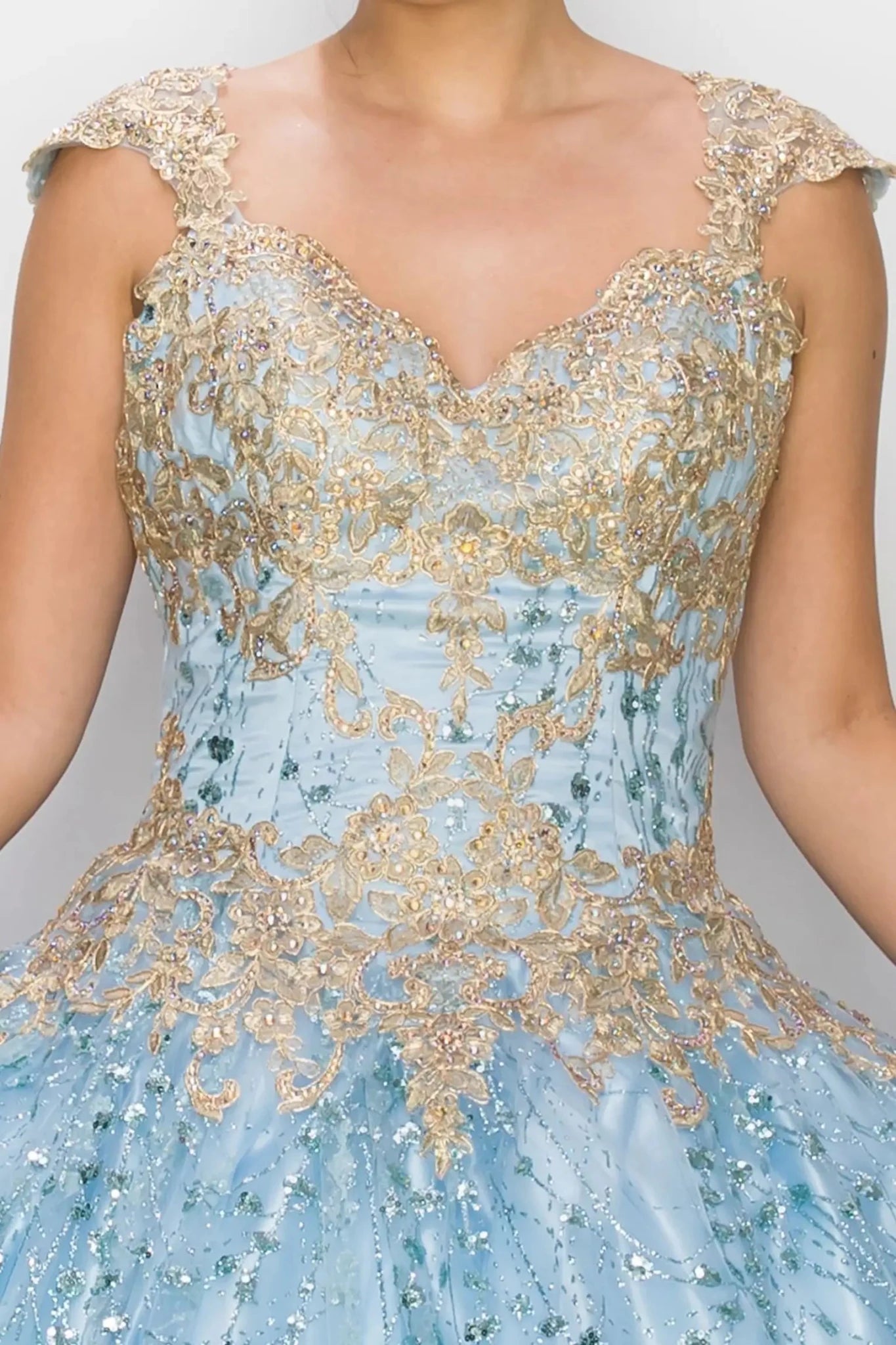 Light blue ball gown with gold embroidery on a plain background