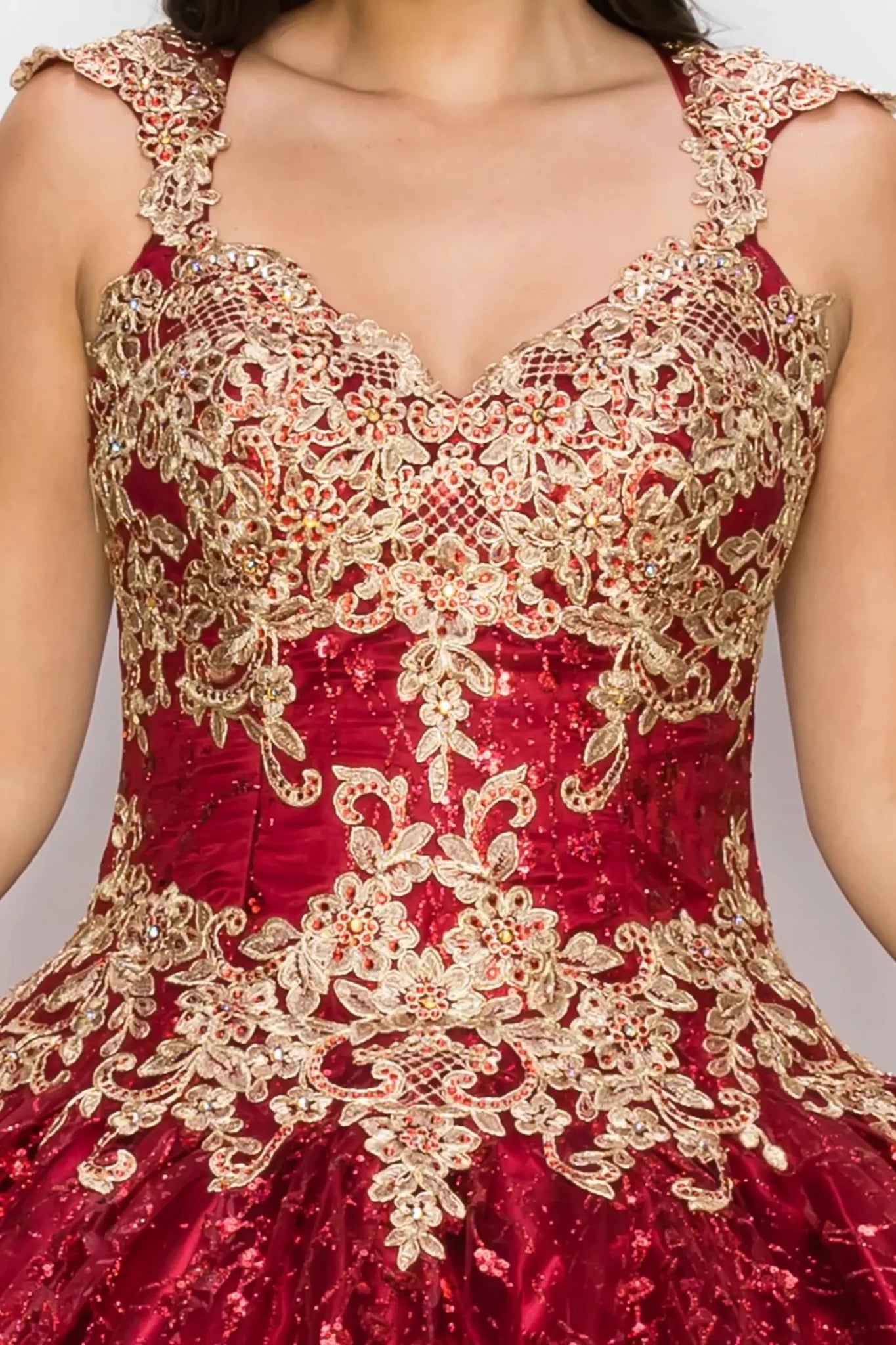 Red dress with gold lace detailing on a plain background