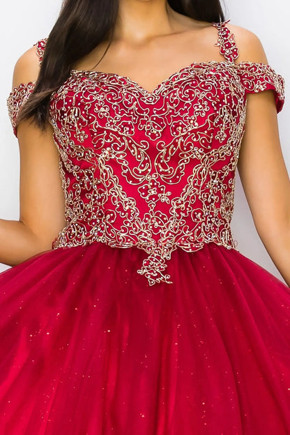 Red quince ball with gold embroidery on a plain background