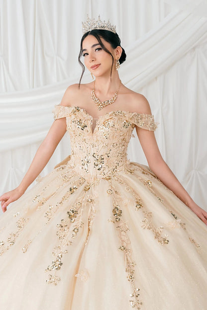 Woman in a beige ball gown with gold embellishments against a white background