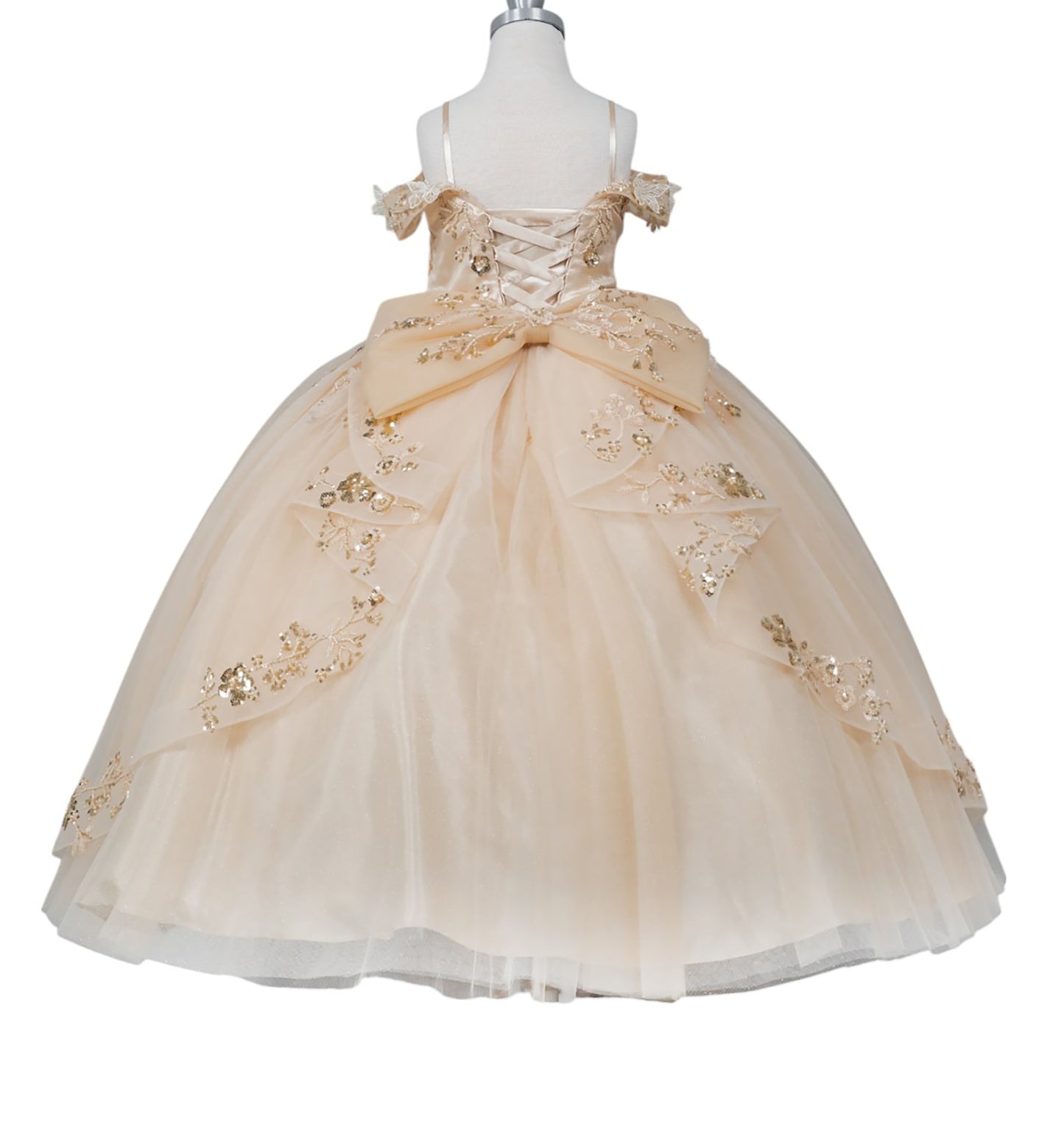 Beige flower girl dress with gold embellishments on a mannequin against a white background
