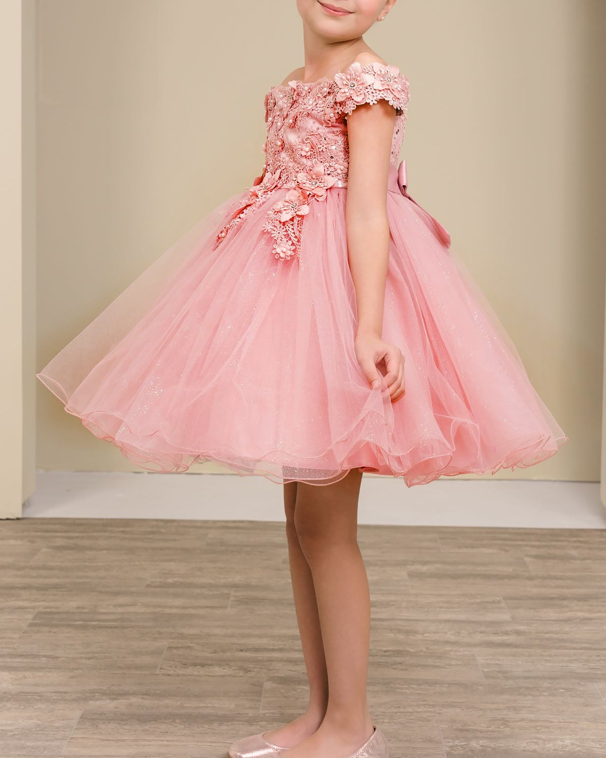 dusty rose floral dress worn by a child on a wooden floor with a beige wall background