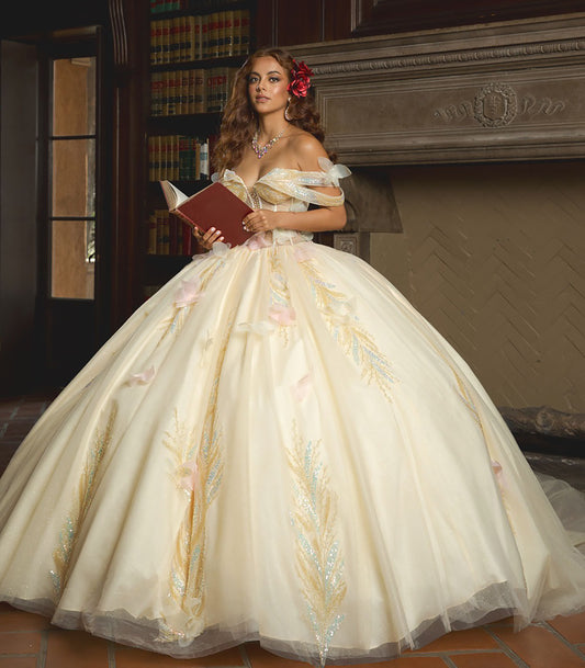 Woman in a white gown with floral details holding a red book in a room with a fireplace.