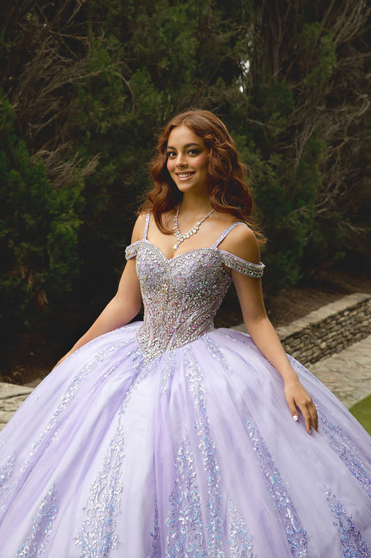 Woman in a sparkling purple gown outdoors with greenery in the background