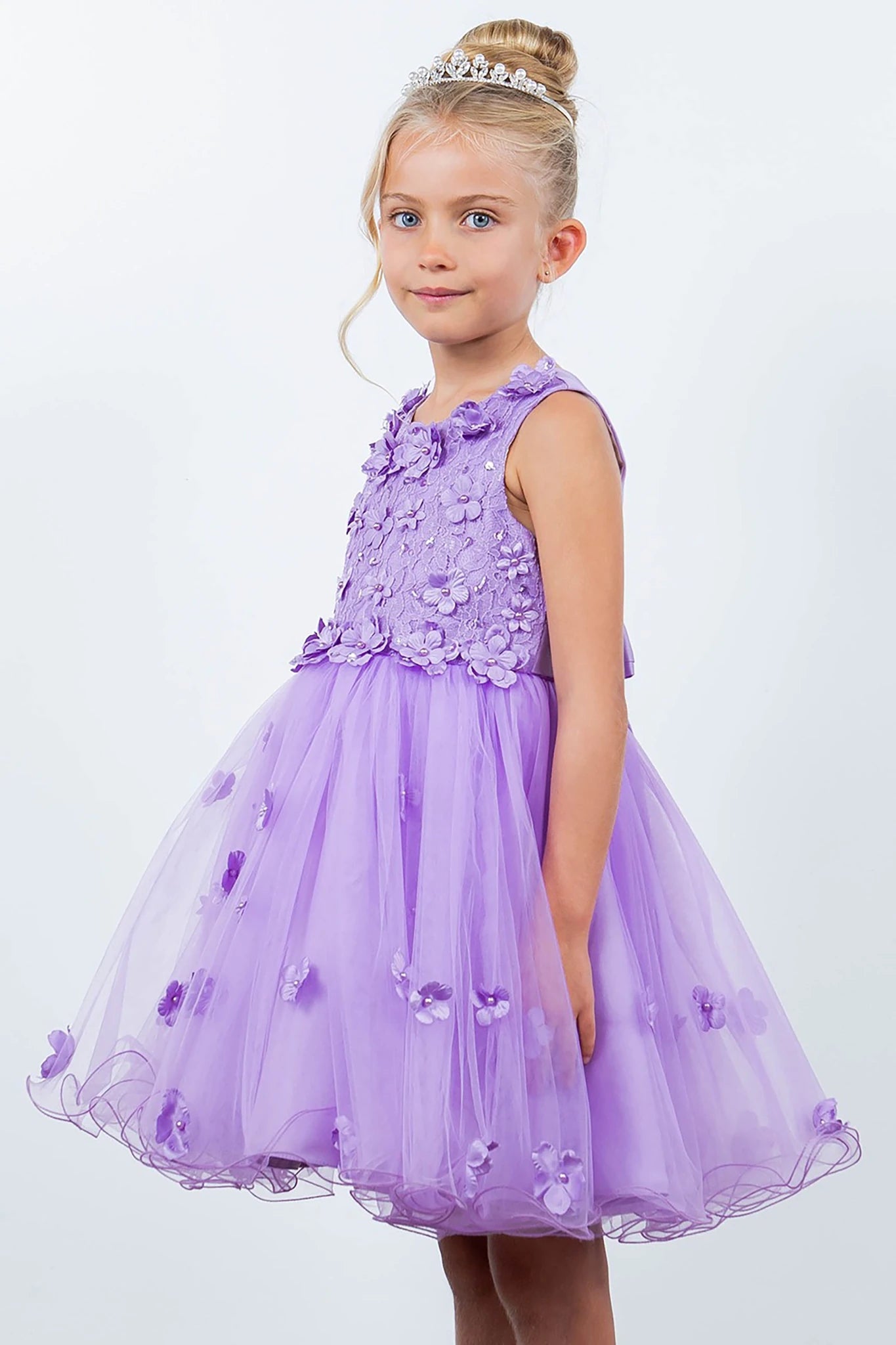 Young girl wearing a lilac dress with floral details on a white background