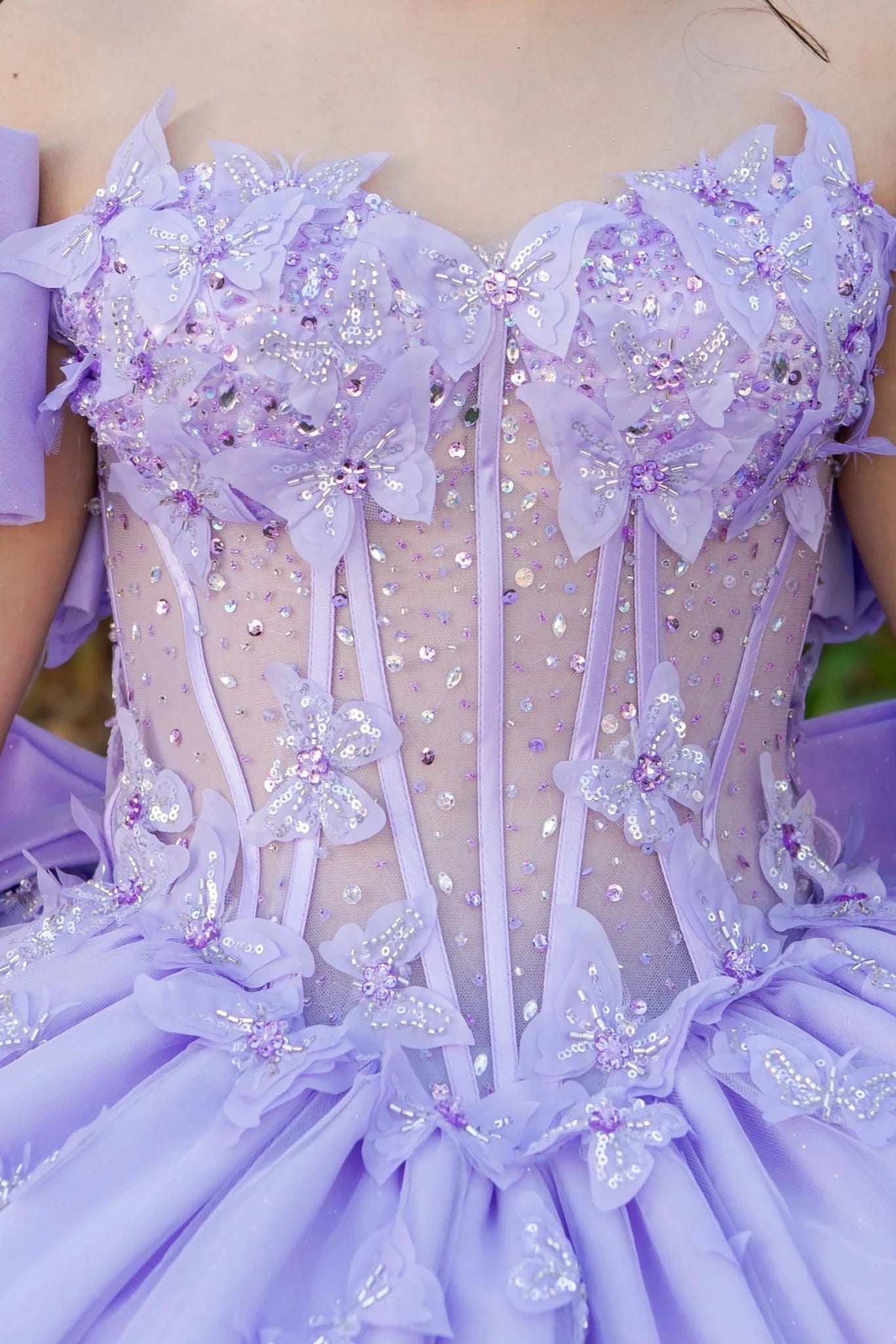 Detailed view of a lilac see through dress with floral and ribbon detail