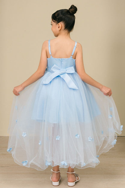 Young girl standing back-facing in sky blue high-low tulle flower girl dress with lace-up bodice, 3D floral appliqué accents, and flowing high-low skirt