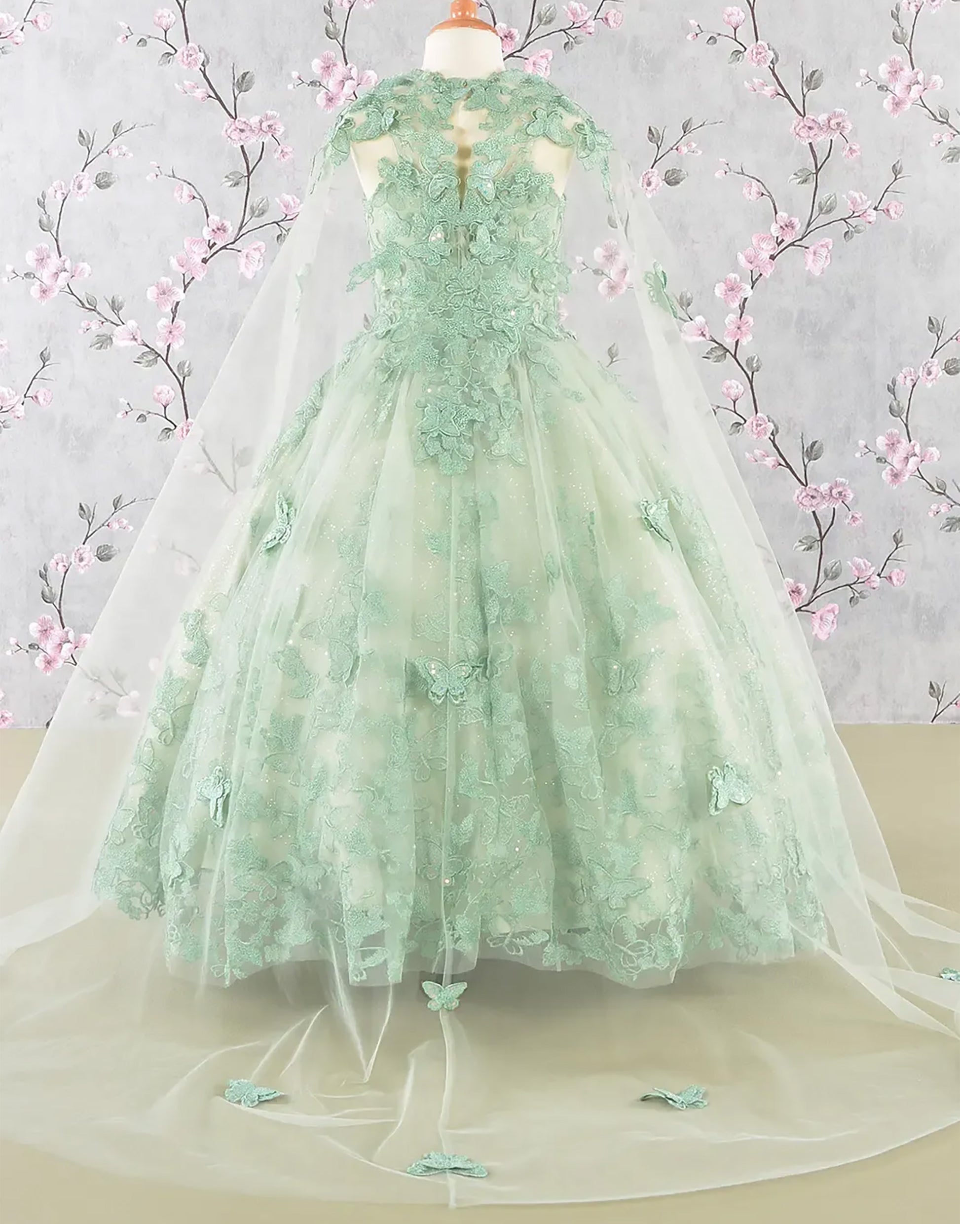 Green lace dress on a mannequin with floral background