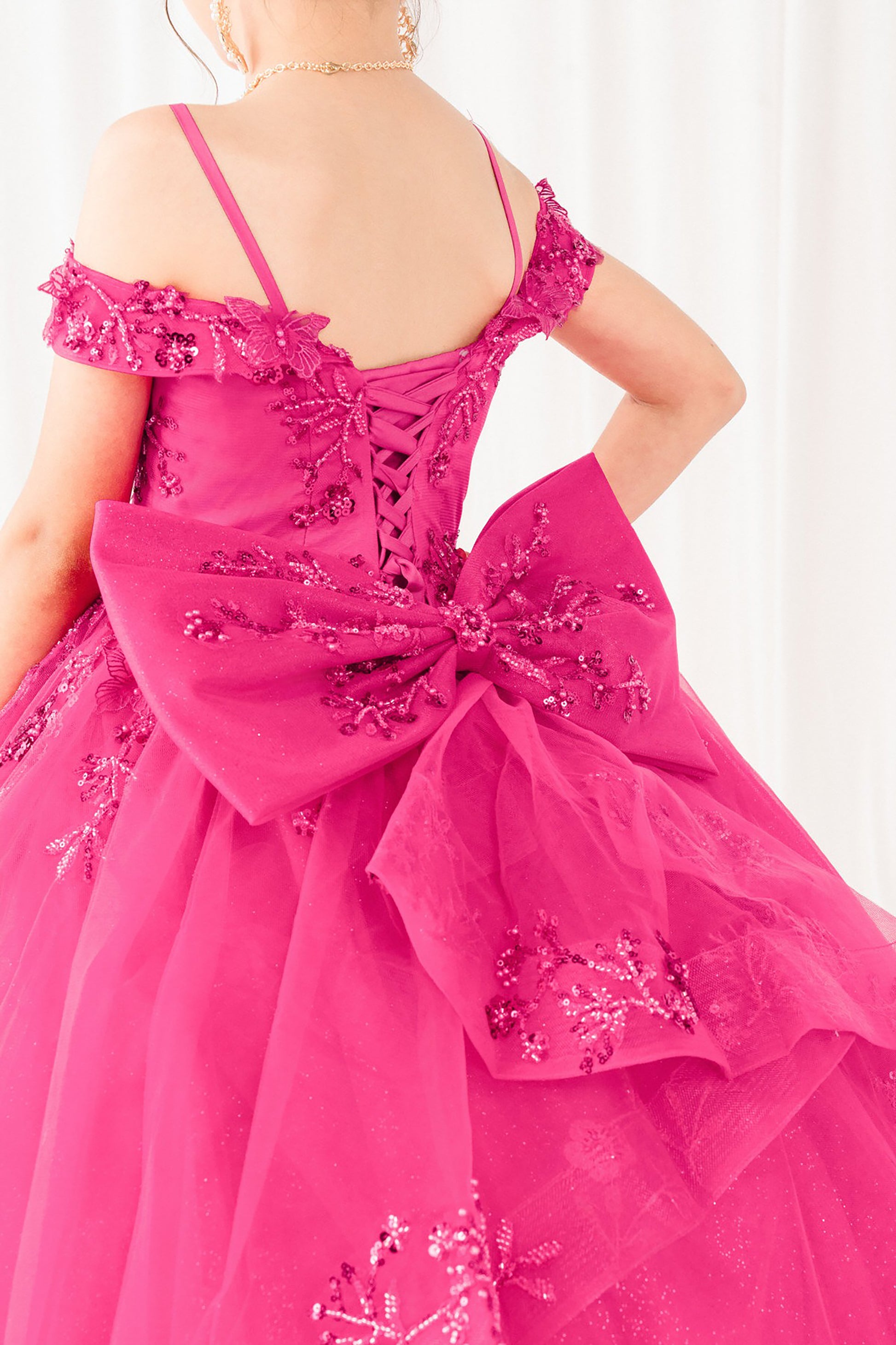 fuchsia formal gown with intricate detailing on a white background