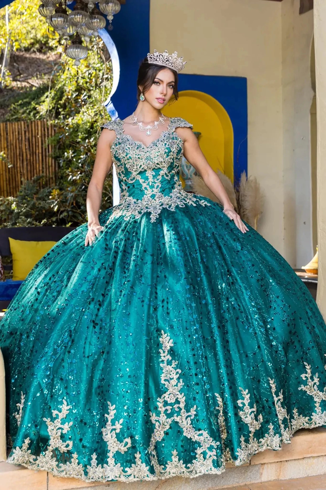 Woman in a teal sequined gown with silver details indoors.