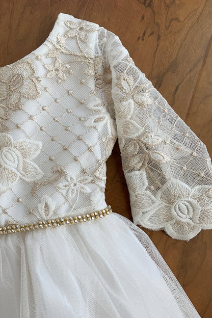 White lace dress with long sleeves on a wooden surface