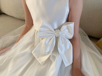 Ivory dress with a large bow detail on a neutral background