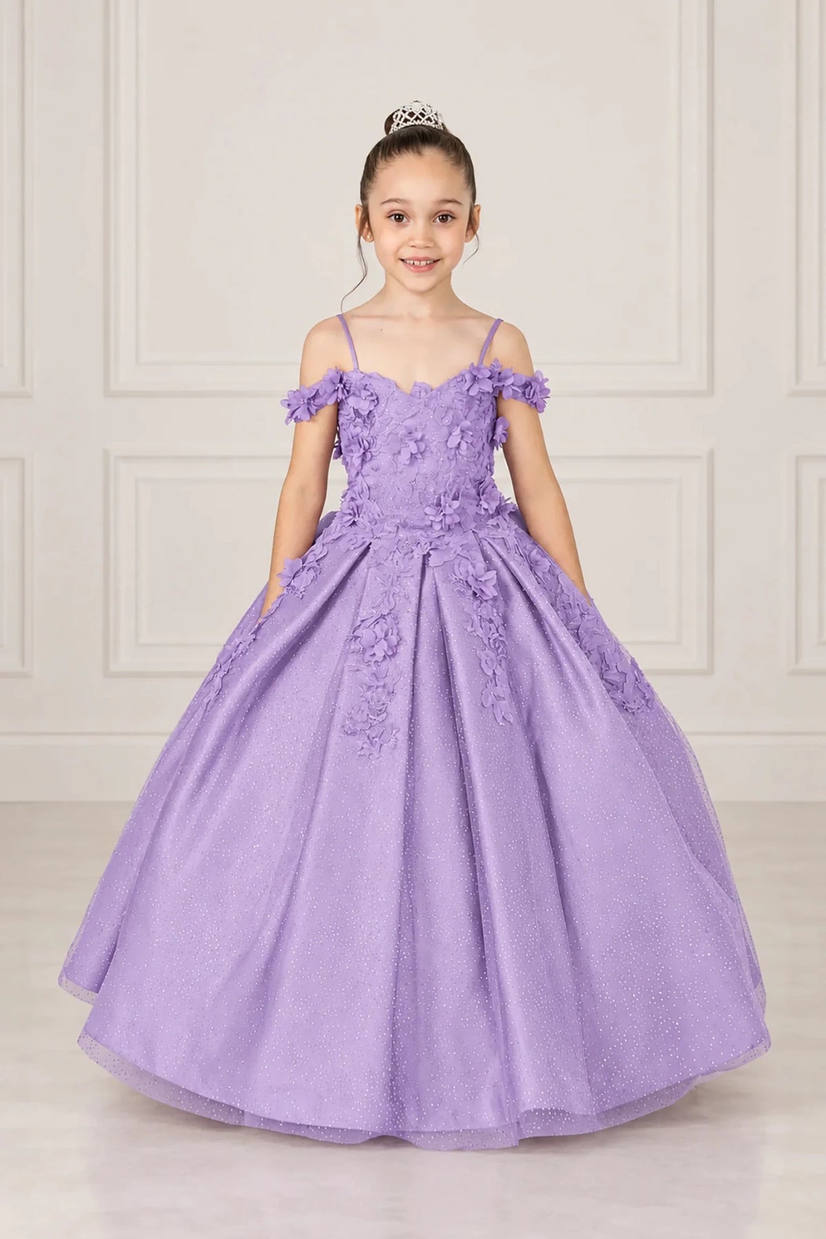 Dimensional flowers trail from the off-shoulder bodice onto the full glitter tulle skirt of this Lilac mini quinceañera gown.
