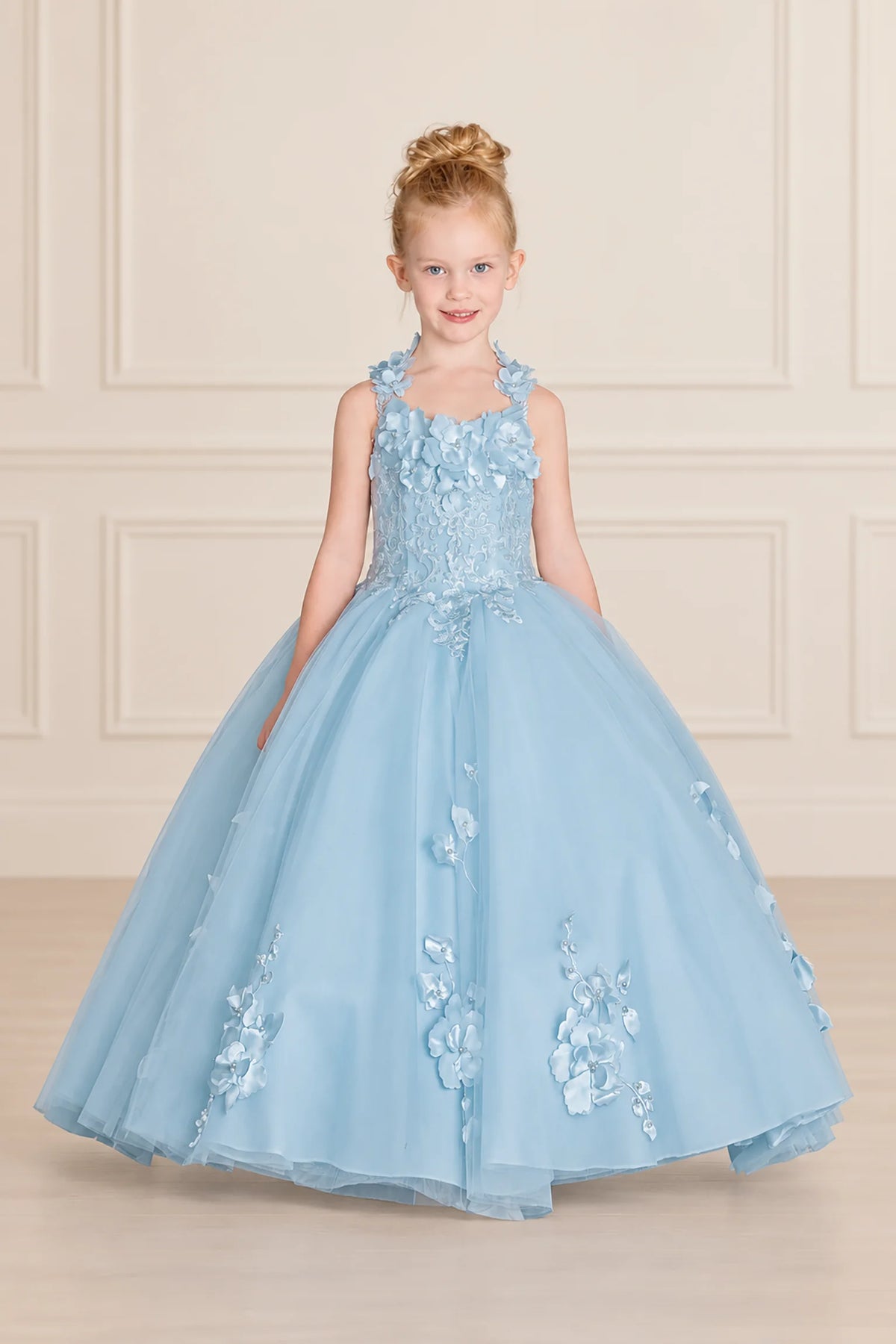 Floral cap sleeves frame the Bahama Blue mini quinceañera gown, with appliqués scattered over its full tulle skirt.