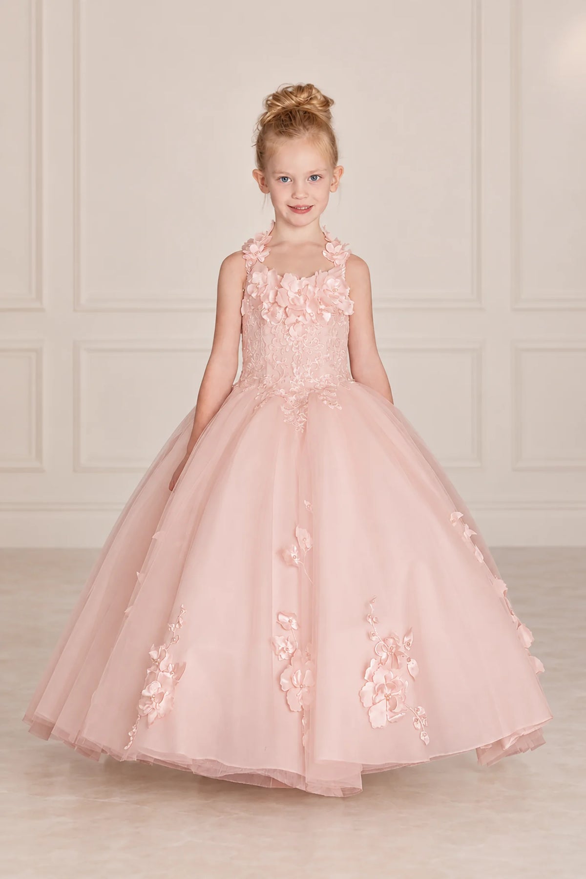 Floral cap sleeves frame the Blush mini quinceañera gown, with appliqués scattered over its full tulle skirt.