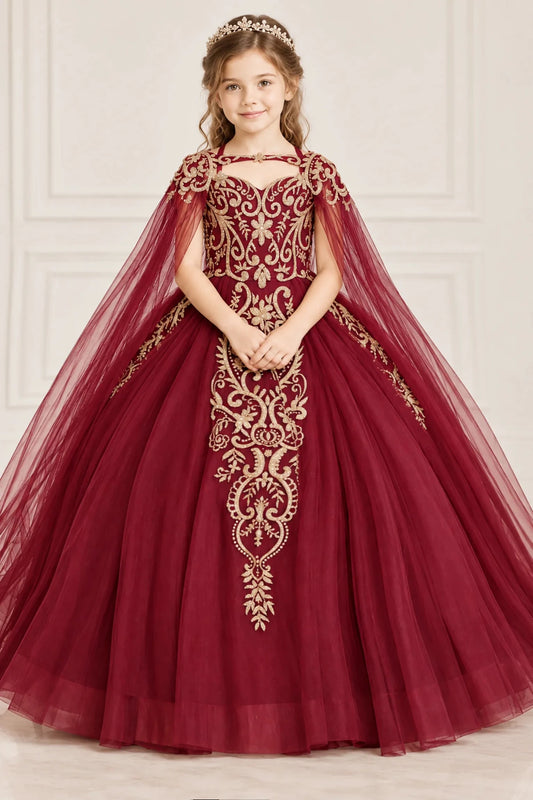 Ornate gold embroidery trails down the bodice and full skirt of this Burgundy mini quinceañera gown beneath a sheer cape.