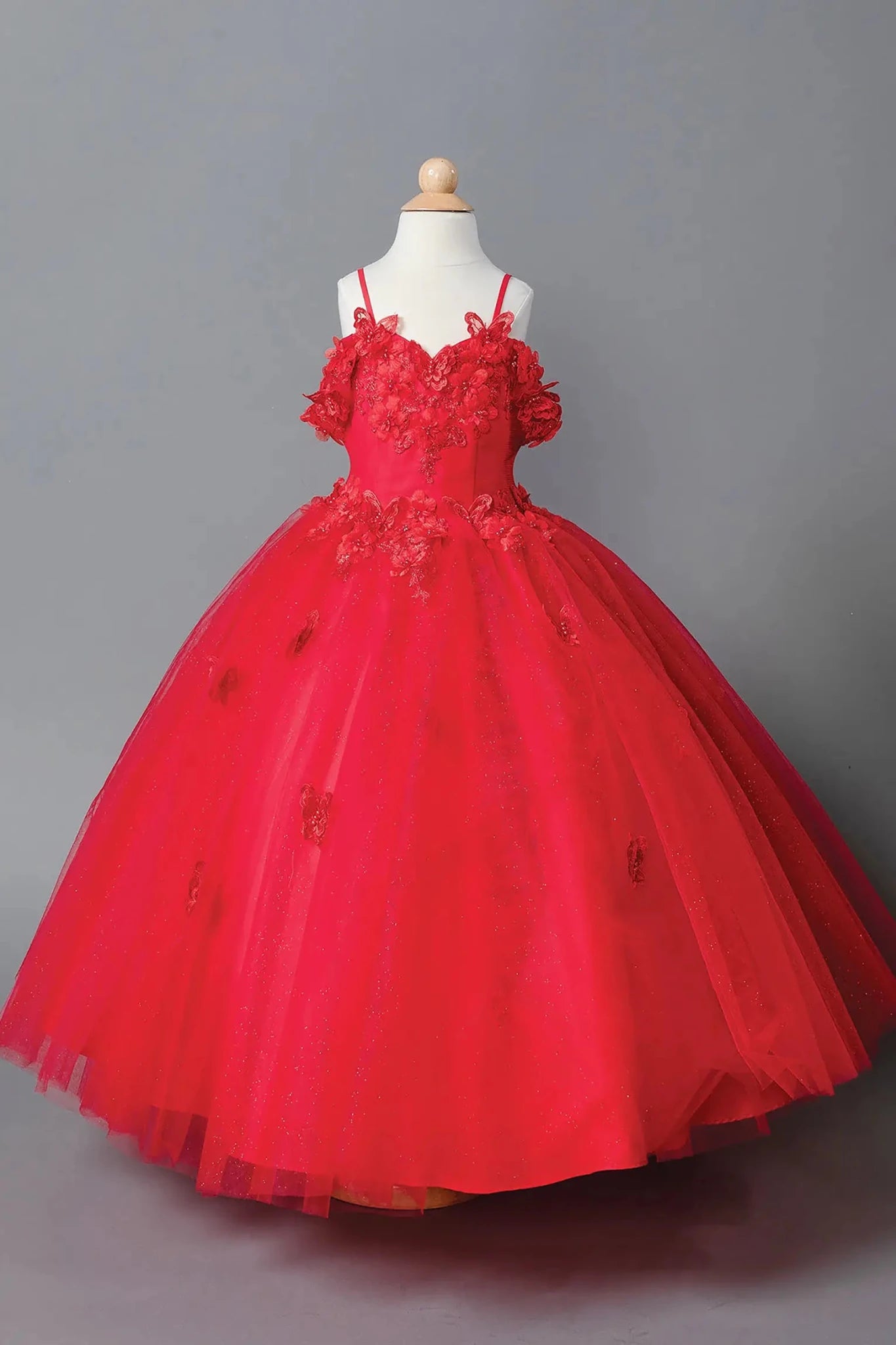 Red kids mini quinceañera mini quince dress with lace-up bodice, floral appliqué detailing, and glitter tulle skirt.