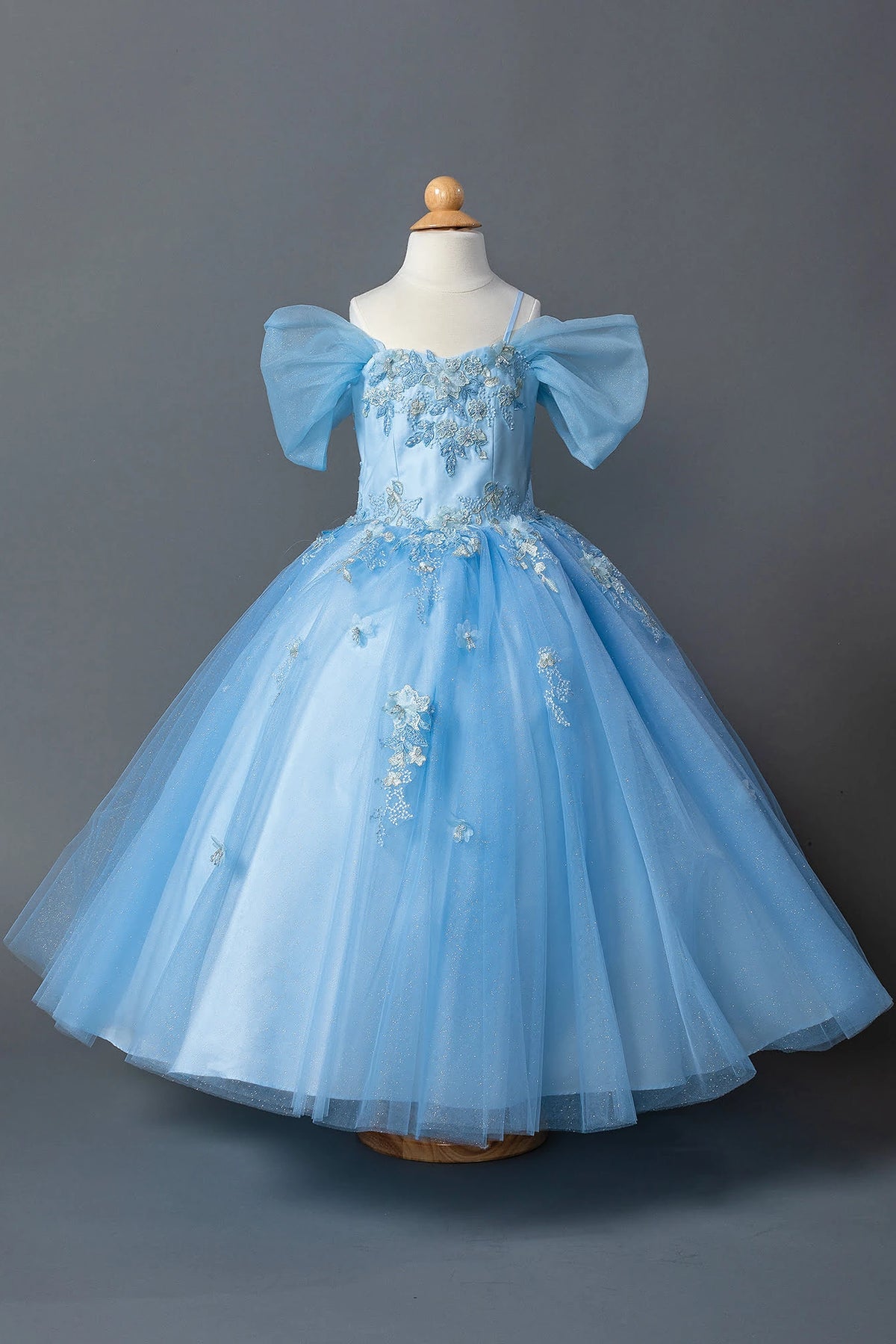 Shimmering from top to hem, the Bahama Blue mini quinceañera dress shows dramatic bow sleeves surrounding a floral embroidered bodice.