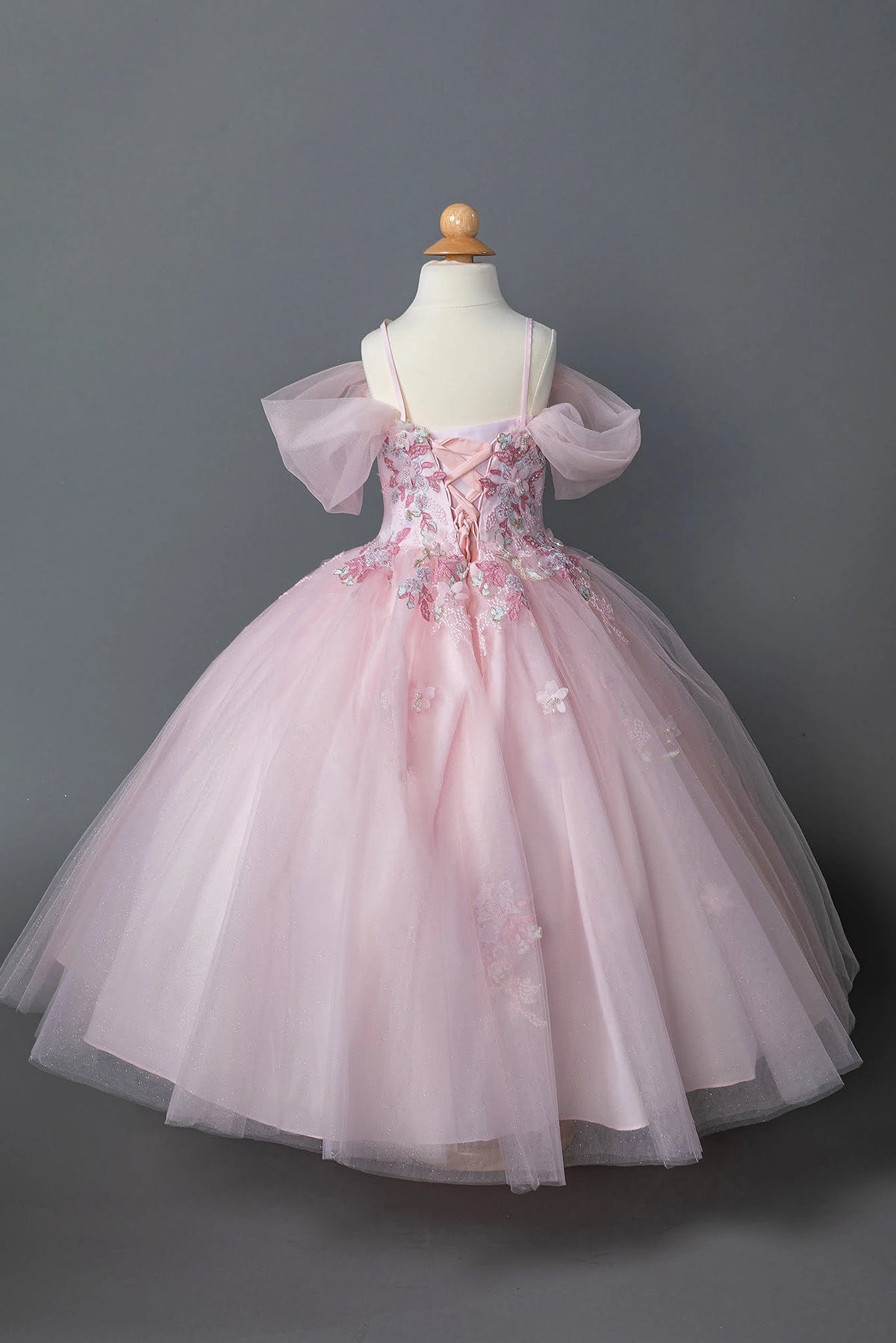 The reverse view reveals, the Pink mini quinceañera dress features lace-up back beneath oversized tulle bows.