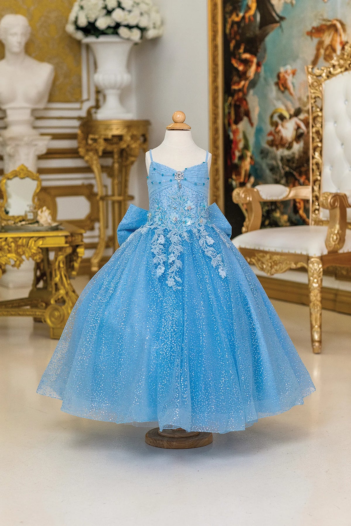 Across the front, the Bahama Blue mini quinceañera dress shows floral embroidery cascading over a sparkling blue skirt.