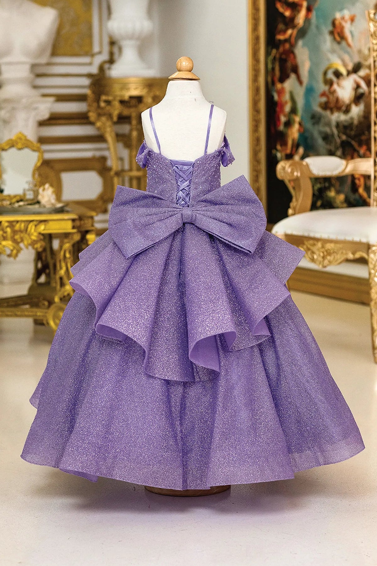 At first glance, the Lilac mini quinceañera dress shows soft glitter tulle flowing from the fitted bodice.