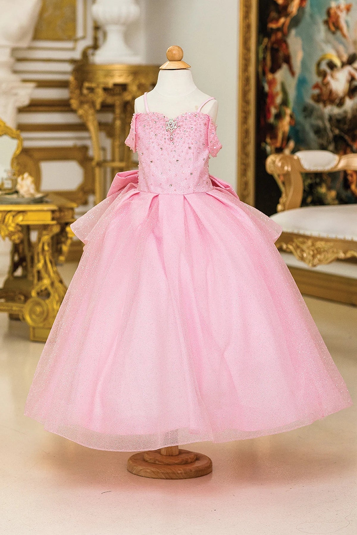 From the neckline, the Pink mini quinceañera dress shows soft glitter tulle flowing from the fitted bodice.