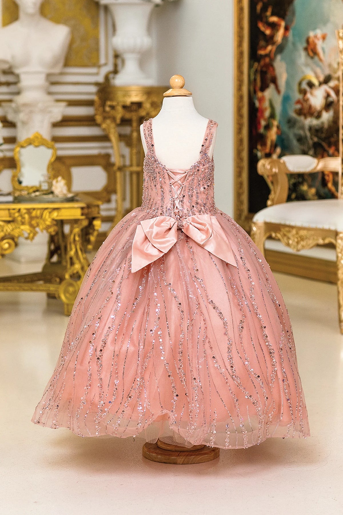 From behind, the Rose Gold mini quinceañera dress features satin bow centered beneath the open back.