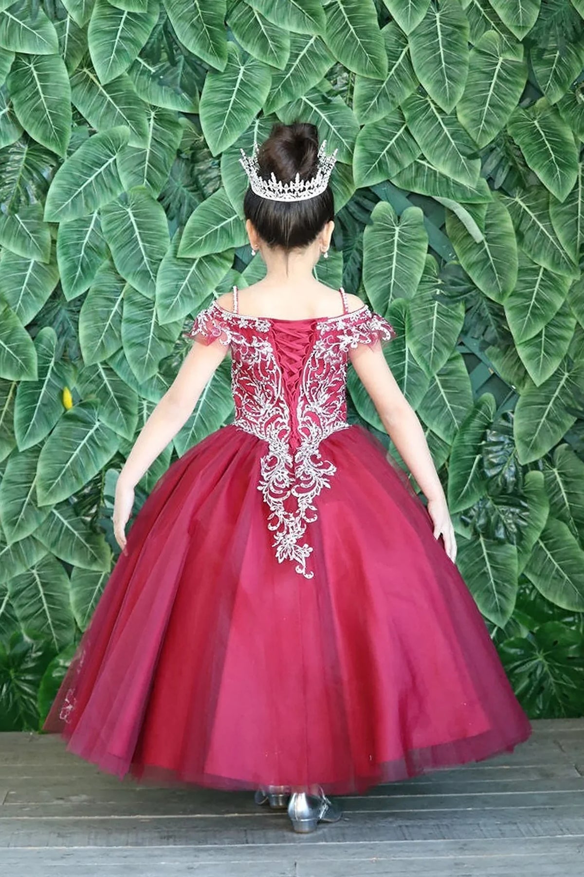 Behind the full skirt, the Burgundy mini quince dress displays its lace-up finish and delicately embroidered tulle skirt.