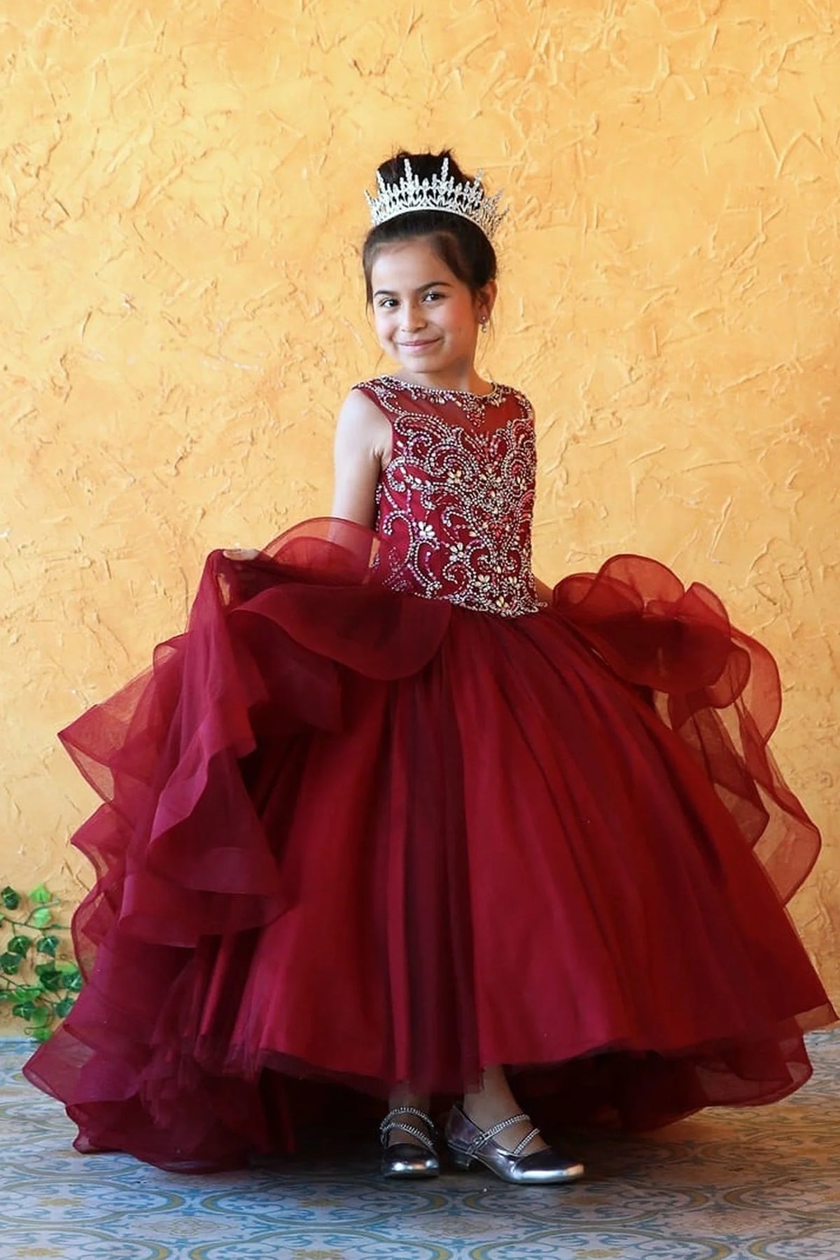 At the bodice and skirt, the Burgundy mini quince dress showcases crystal-embellished sleeveless bodice and cascading layered ruffle skirt.