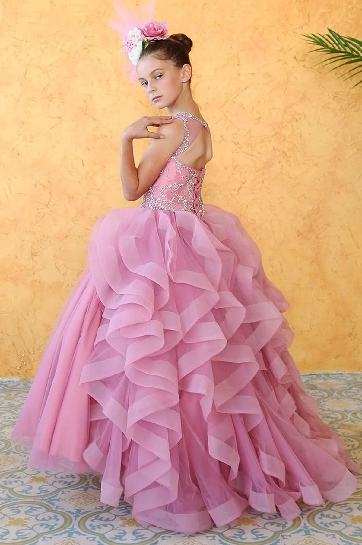 In full view, the Dusty Pink mini quince dress showcases crystal-embellished sleeveless bodice and cascading layered ruffle skirt.