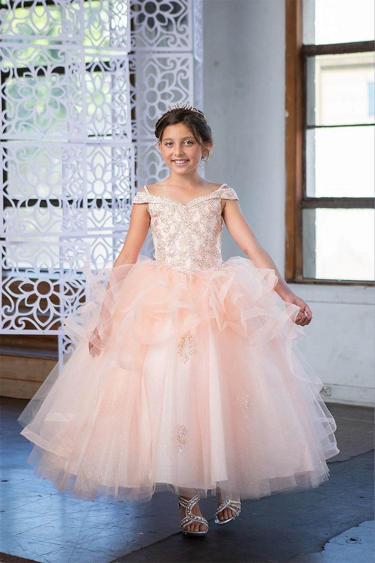 Across the silhouette, the Blush Pink mini quince dress showcases sparkling jeweled fitted bodice and layered formal skirt with dimensional tiers.