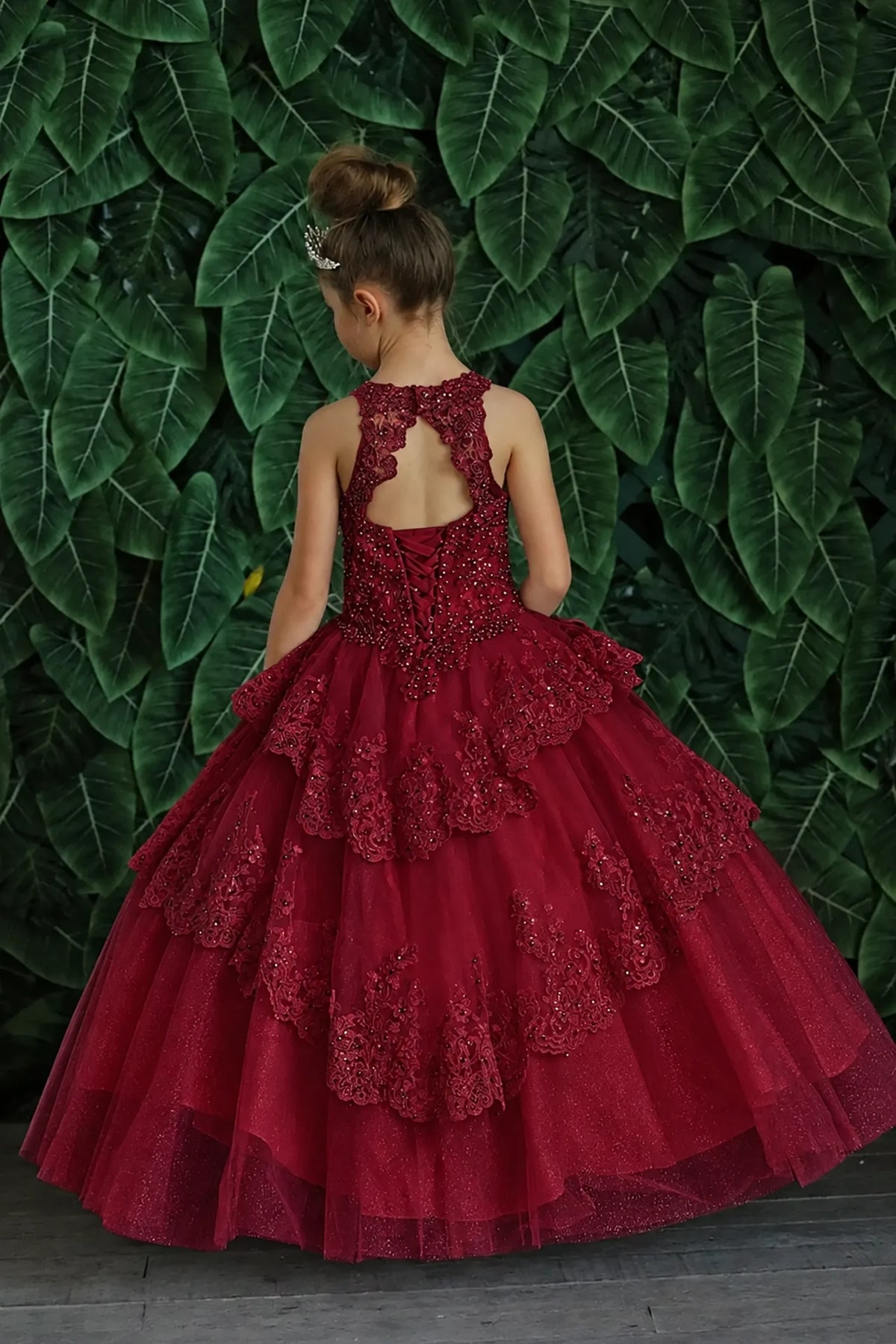 Along the back, the Burgundy mini quince dress displays its lace-up finish and full layered tulle skirt with ruffle tiers.