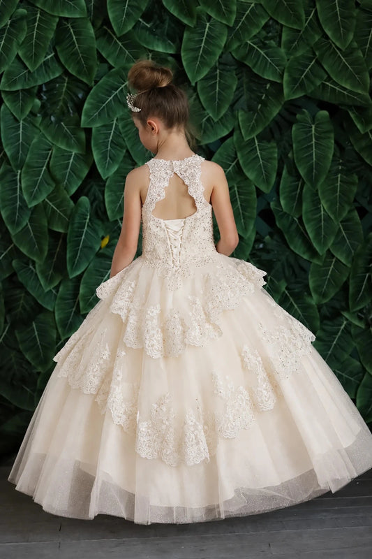 Turning to the back, the Champagne mini quince dress displays its lace-up finish and full layered tulle skirt with ruffle tiers.
