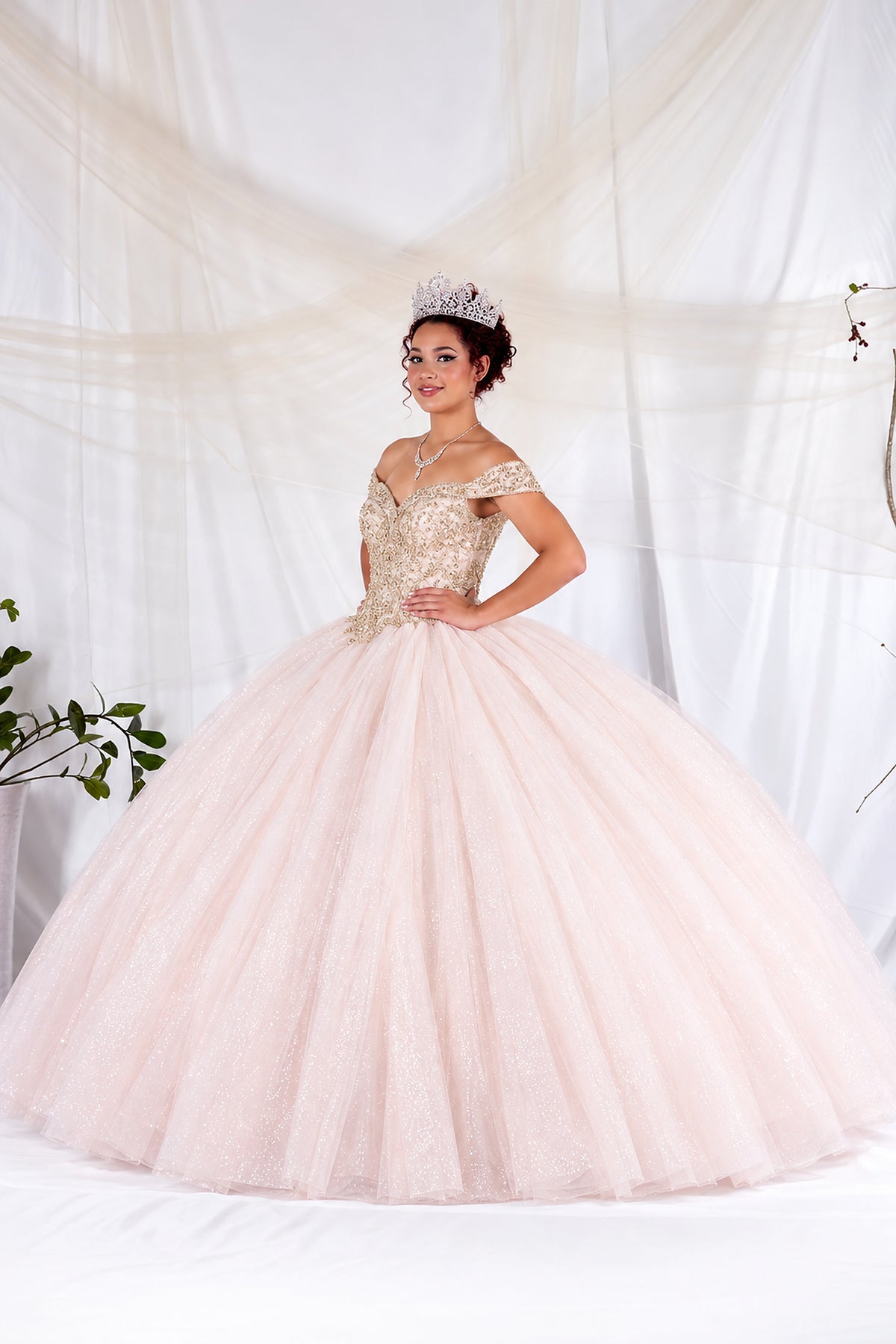 Blush/Gold quinceañera ball gown with floral embroidery, off-shoulder straps and a full tulle skirt.