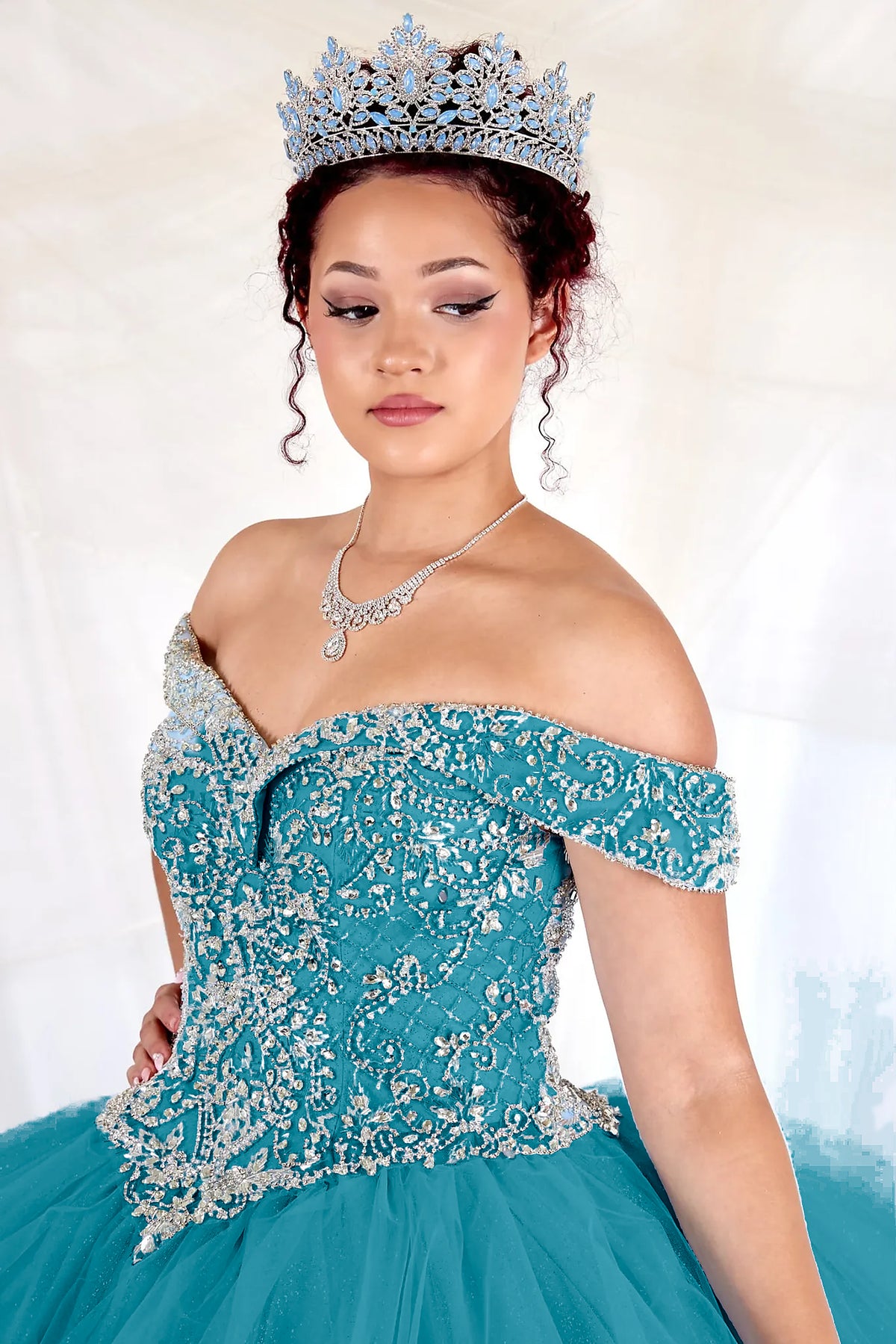 Close-up of the ornate floral embroidery along the neckline of the Jade/Gold quinceañera ball gown.