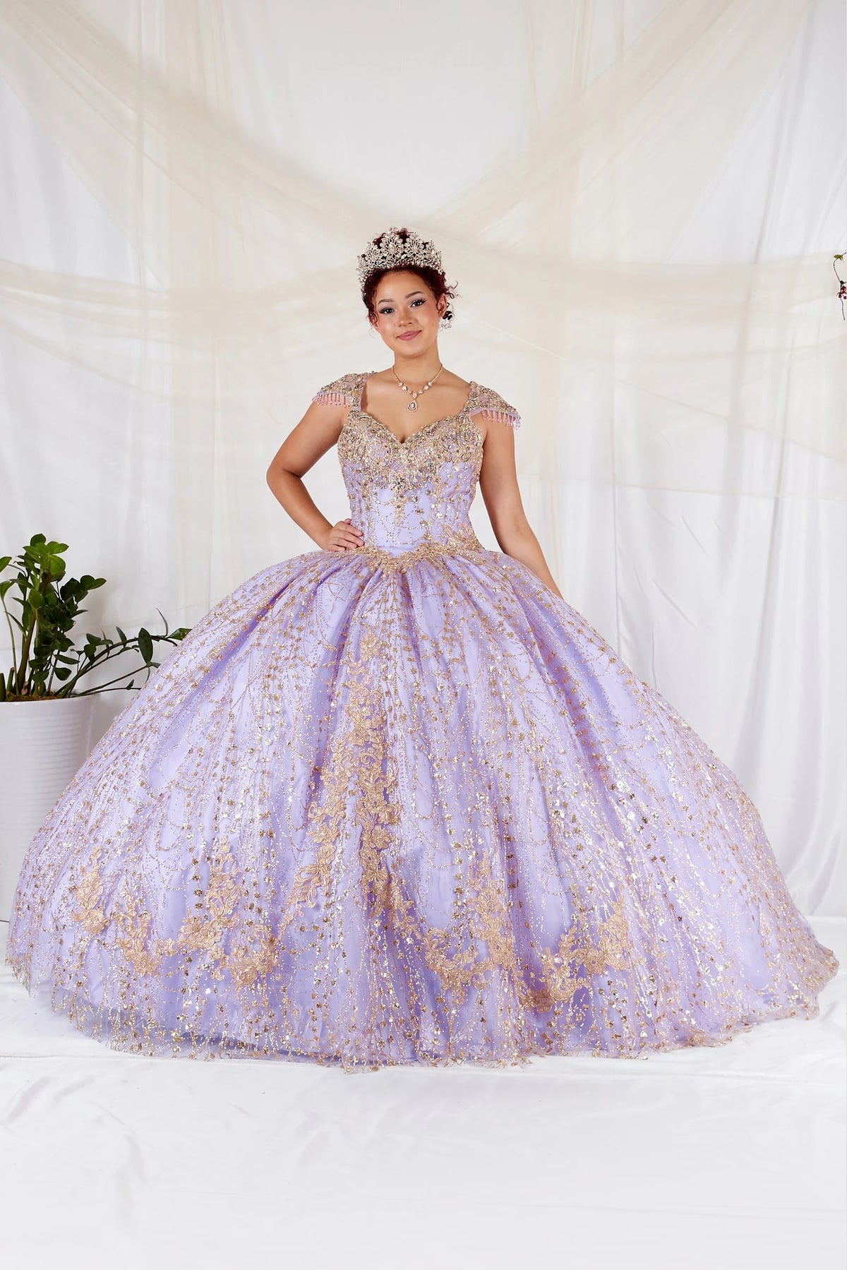 Lilac Gold quinceañera dress showcases metallic embroidered scrollwork above sparkling full ball gown silhouette.