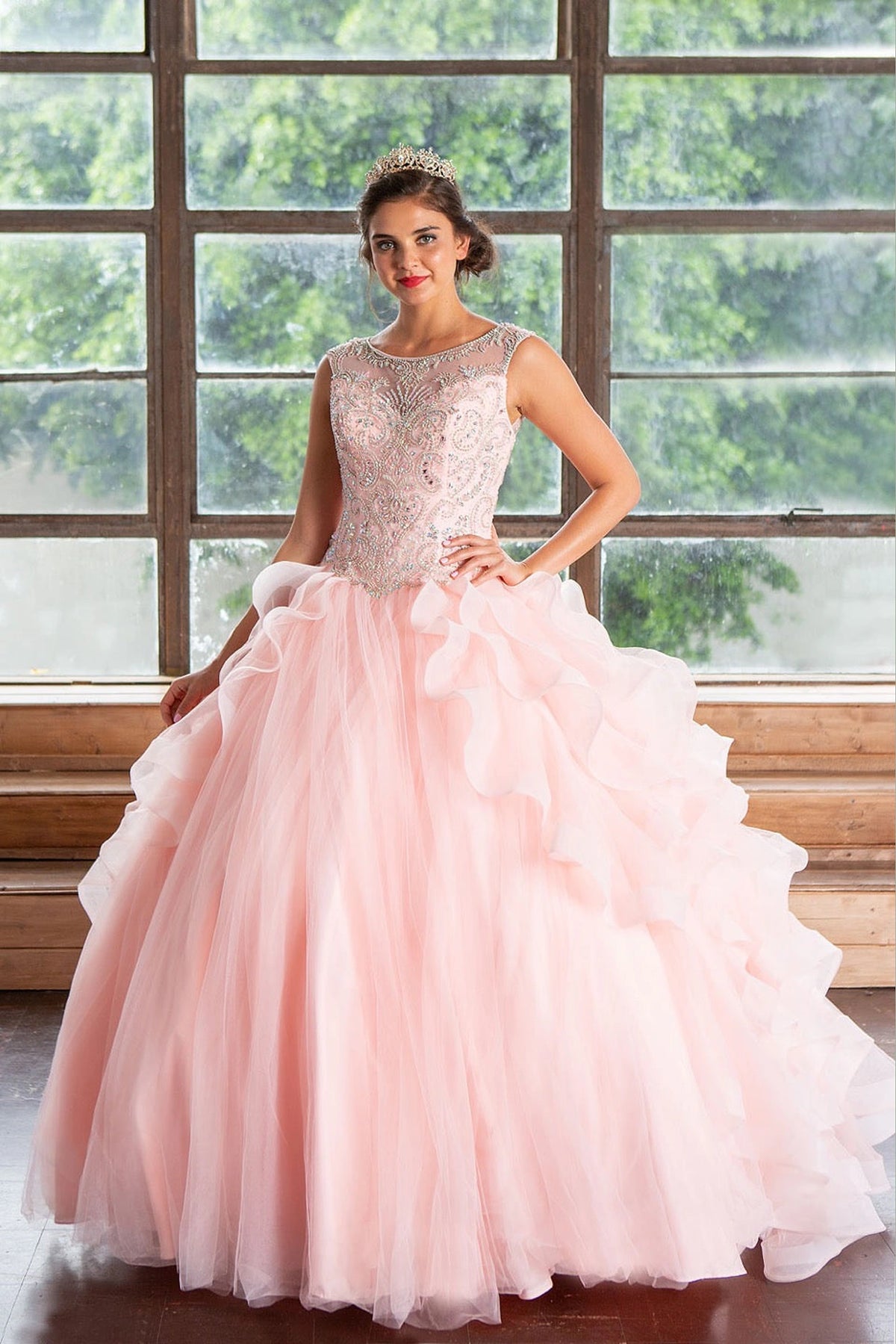 Blush Pink quinceañera dress showcases cascading dimensional ruffle skirt above embellished fitted bodice.