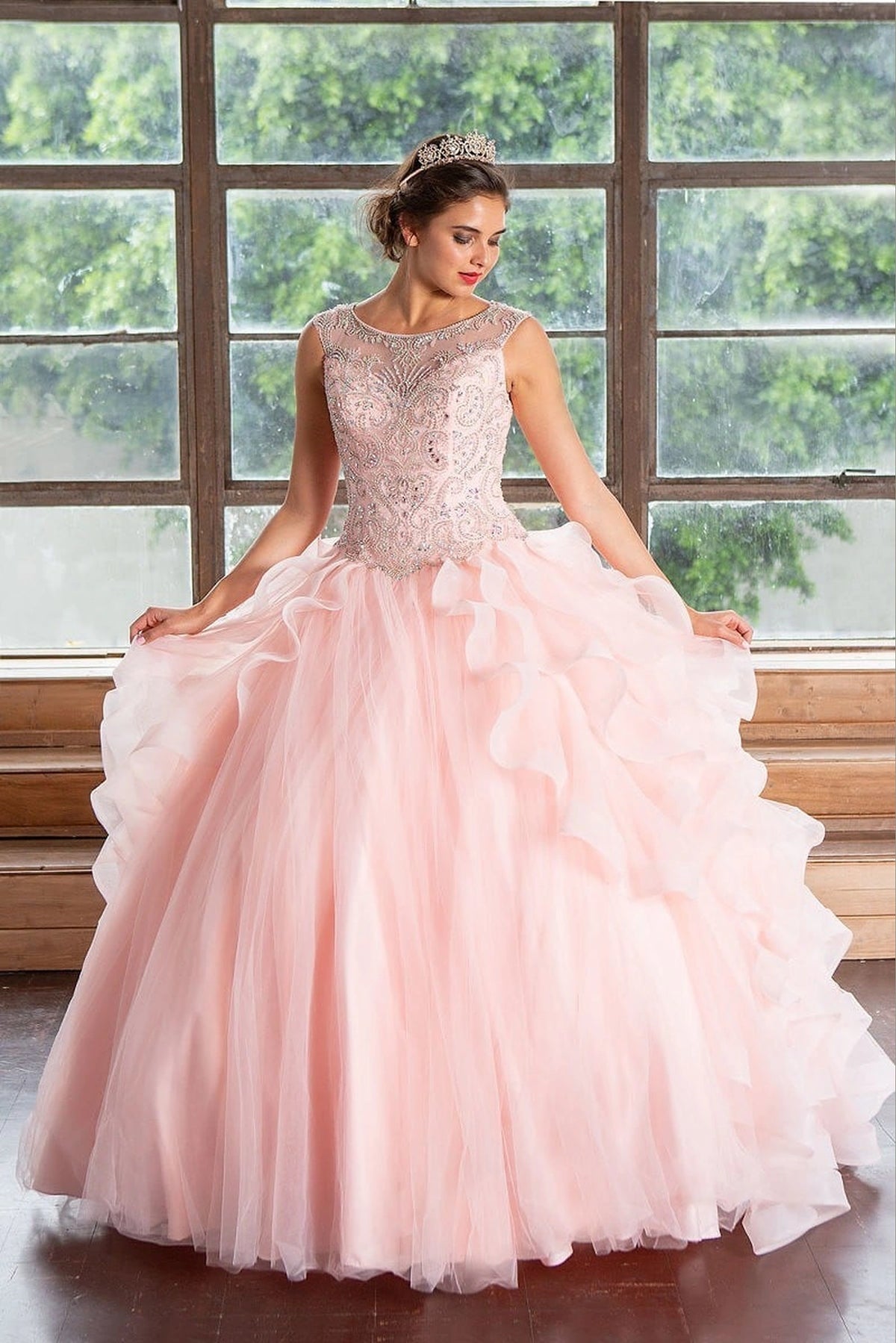 Cascading dimensional ruffle skirt defines the Blush Pink quinceañera dress in this detailed view.