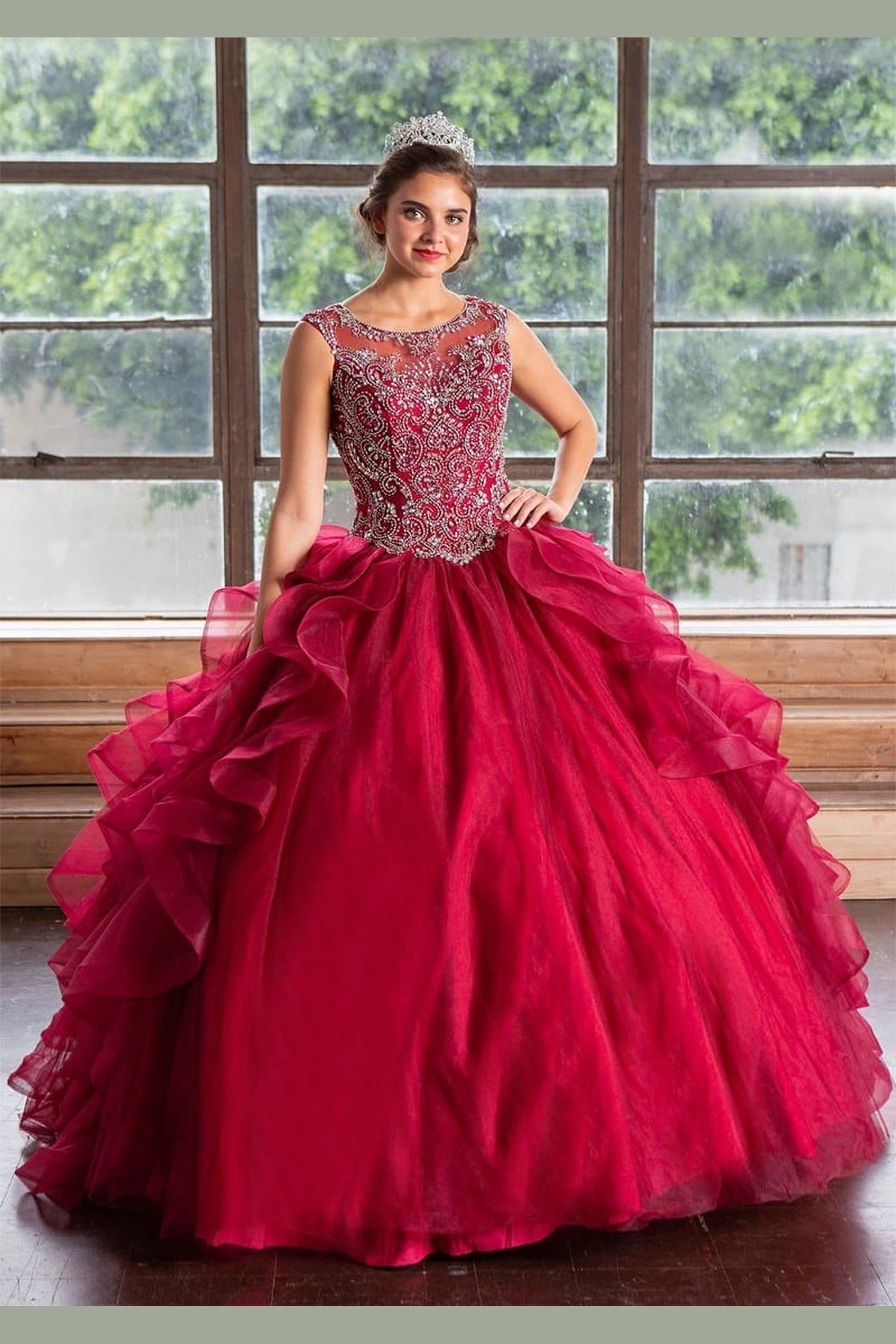 Burgundy quinceañera dress showcases cascading dimensional ruffle skirt above embellished fitted bodice.