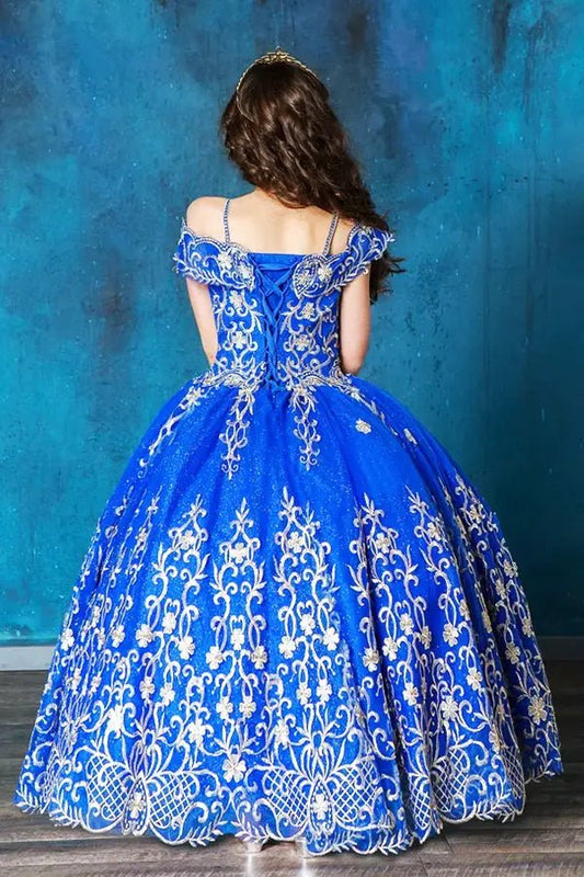 Kid standing back-facing in royal blue ball gown with lace-up closure, embroidered bodice, and cascading full skirt