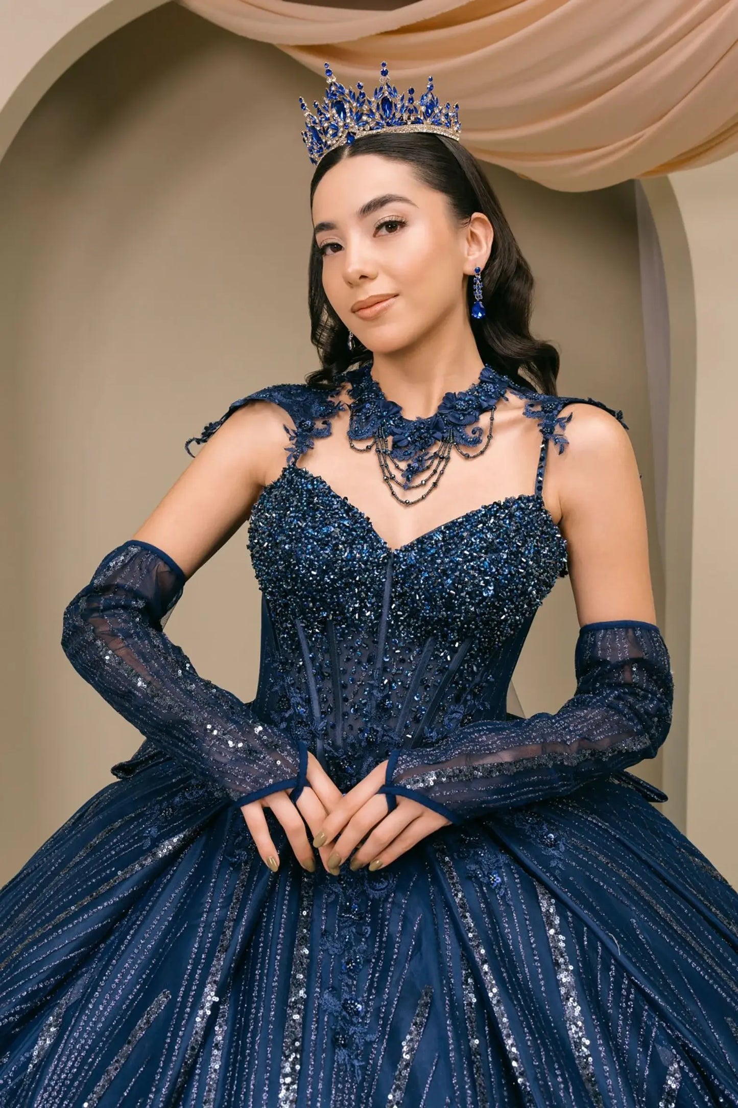 Front Close-up of woman wearing navy quinceañera royal dress with beaded corset bodice, sweetheart neckline, choker detail, and shimmering textured skirt
