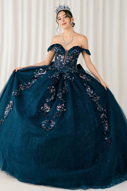 Woman wearing navy quinceañera royal dress with embroidered beaded corset bodice, shimmering textured skirt, cathedral train, detachable cape, and gloves