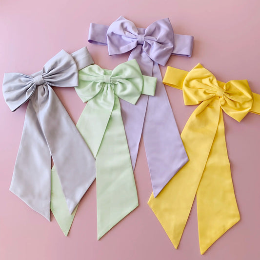 Set of colorful satin bows on a pink background